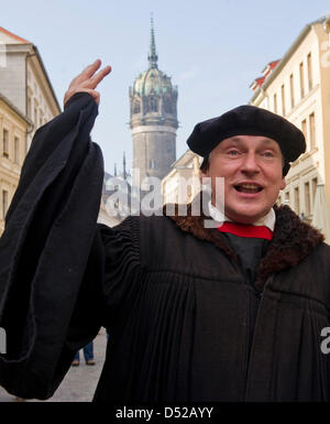 Attore Nernhard Naumann, vestito come Martin Lutero (1483-1546), passeggiate al famoso castello chiesa a Wittenberg (Germania), 31 ottobre 2010. Secondo deliverances, Martin Lutero mise il suo 95 tesi contro la vendita di indulgances alla porta della chiesa il 31 ottobre 1517. Questo è detto di essere l'inizio del mondiale per la riforma della chiesa. Foto: Hendrik Schmidt Foto Stock