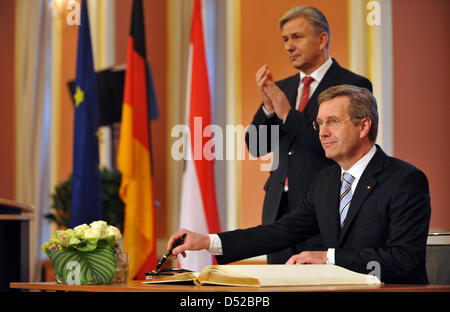 Il Presidente tedesco Christian Wulff segni della città libro d'oro accanto a Berlino il sindaco Klaus Wowereit (L) durante la sua prolusione visita di Berlino presso la sala grande del rosso municipio di Berlino (Germania), 2 novembre 2010. Sullo sfondo si blocca un dipinto del Congresso di incontro di Berlino nel 1878. Wulff e Berlino Wowereit sindaco visita Humbodt University, la Porta di Brandeburgo e la scar Foto Stock