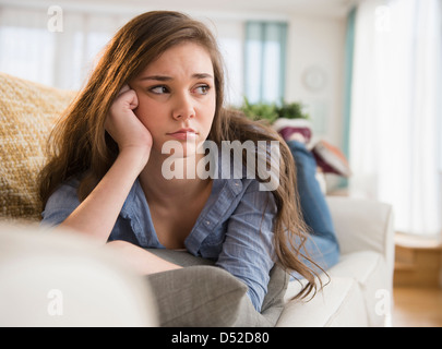 Ansioso ragazza ispanica posa sul divano Foto Stock