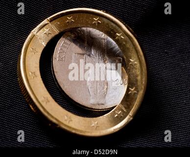 Illustrazione - un'immagine illustrata mostra un cipriota piegata euro moneta il cui nucleo è sceso fuori sul bordo esterno della moneta a Francoforte sull'Oder, Germania, 22 marzo 2013. Foto: PATRICK PLEUL Foto Stock