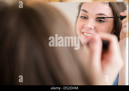 Ragazza ispanica applicando specchio dello specchio Foto Stock