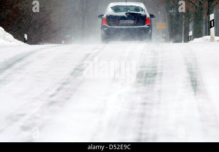 Una unità di auto su una strada di campagna tra Neuendorf e Pokrent, Germania, 24 febbraio 2010. La nuova insorgenza di inverno ha creato Neve e strade ghiacciate e causato il traffico pesante ostruzioni nel nord della Germania. Foto: Jens Buettner Foto Stock