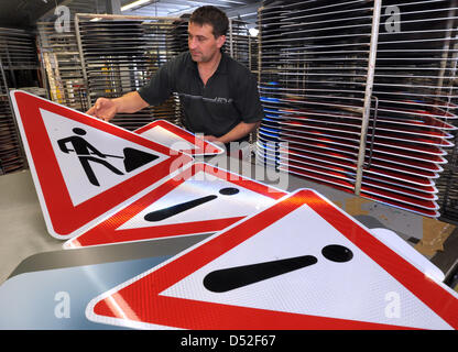 I cartelli stradali che simboleggia "costruzione sito', 'danni su strada' e 'Attenzione' sono molto richiesti dalla segnaletica stradale Beutha fabbrica, Germania, 25 febbraio 2010. Strade tedesche hanno sofferto gravi e lungo inverno, buche devono essere applicate le patch a partire witgh disgelo meteo. Foto: Wolfgang Thieme Foto Stock