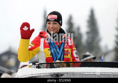 Biatleta tedesca Magdalena Neuner onde da un auto e presenta le sue medaglie durante il ricevimento nella sua città Wallgau, Germania, 05 marzo 2010. Neuner ha vinto due medaglie d'oro e una medaglia d'argento ai Giochi Olimpici Invernali 2010 a Vancouver in Canada. Una fase è stata appositamente stadio costruito sulla piazza della città e per l'occasione. Foto: TOBIAS HASE Foto Stock