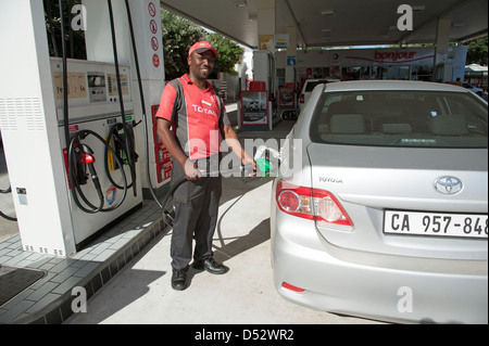 Pompa benzina attendant auto di riempimento di carburante in una stazione di rifornimento a Knysna Sud Africa Foto Stock