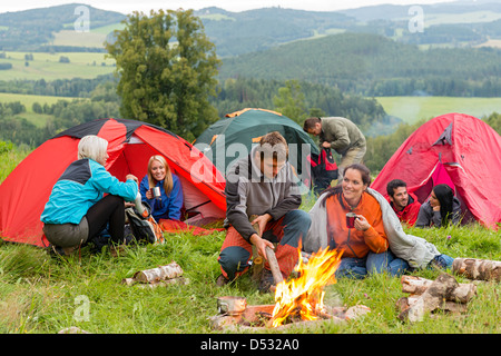 Un gruppo di giovani studenti trascorrere weekend insieme in tende campfire Foto Stock