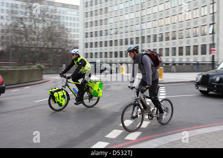 I ciclisti, compresa una risposta medica dell'unità e del traffico in ingresso una rotatoria a Londra, Inghilterra. Foto Stock