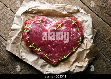 Carni bovine il cuore in primo piano della carta Foto Stock