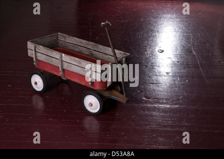 Vintage rosso arrugginito metallo Carro di utilità sul vecchio pavimento in legno Foto Stock