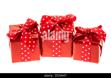 Tre regali avvolti in carta di colore rosso con nastro polkadot Foto Stock