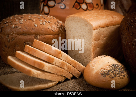 Loave di pane, cereali su sfondo bianco Foto Stock