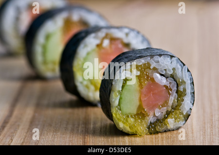 Sushi in fila sul tappetino di bambù Foto Stock