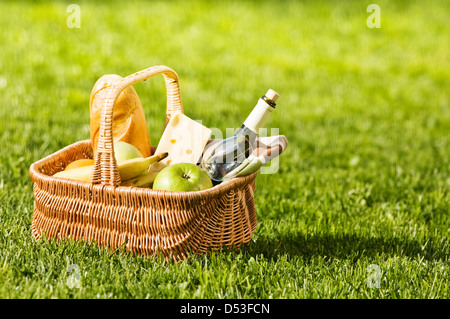 Cesto picnic sul prato verde Foto Stock