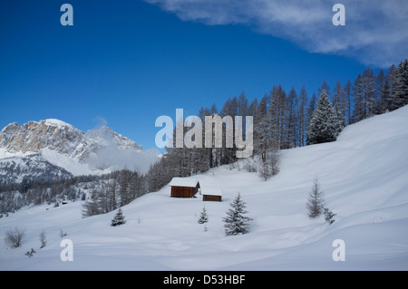 Fienili in legno su un pendio nevoso in Alta Badia ski resort ski resort vicino a Corvara nelle Dolomiti, Alto Adige, Italia Foto Stock