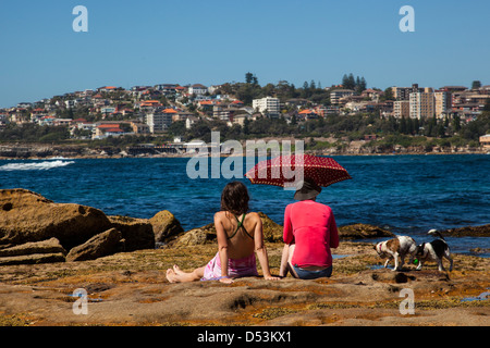 La donna seduta sulla riva a Sydney, ammirare il panorama Foto Stock