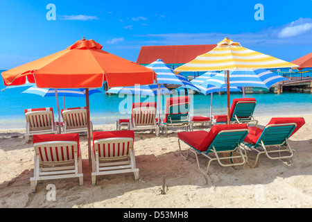 Sedie a sdraio e ombrelloni sulla spiaggia in un paradiso tropicale Foto Stock