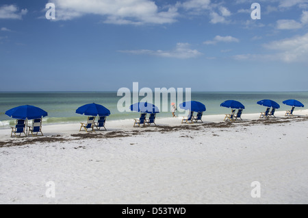 Giovane donna cammina spiaggia da sedie a Caladesi Island State Park (MR). Foto Stock