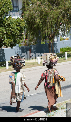 Le donne africane che trasportano tessuti ripiegato sulle loro teste, venditori ambulanti in Knysna lungo la Garden Route del Sud Africa Foto Stock