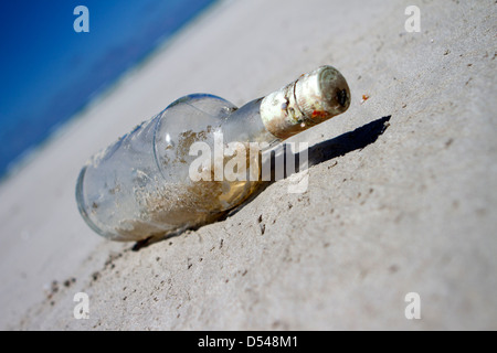 Una bottiglia lavato fino a una spiaggia. Foto Stock