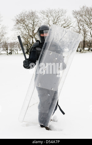 Funzionario di polizia vestito in tenuta da sommossa con schermatura in snow Foto Stock