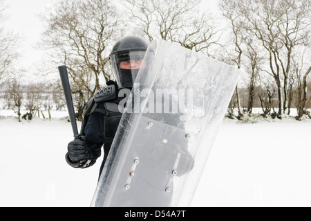 Funzionario di polizia vestito in tenuta da sommossa con schermatura in snow Foto Stock