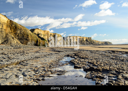 Cascata di oltre scogliere di Dunraven Bay, Southerndown, South Wales, Regno Unito Foto Stock