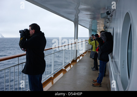 I passeggeri a bordo di hurtigruten nave passeggeri vela attraverso fiordi durante l'inverno la Norvegia europa Foto Stock