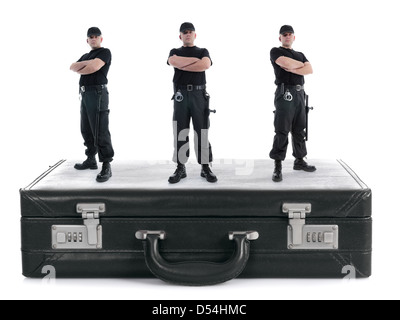 Tre ragazzi di sicurezza permanente sulla crittografia nero valigia shot su bianco, il concetto di sicurezza Foto Stock