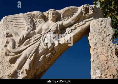 La scultura in pietra sollievo dalla porta di Eracle di Nike alata la dea della vittoria di antiche rovine di Efeso Turchia con il blu del cielo Foto Stock