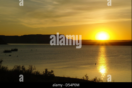 Sunrise giallo lato luminoso a sommità piatta collina plateau sulle acque del lago Powell, visto dal lago Powell Resort, Arizona, Stati Uniti d'America Foto Stock