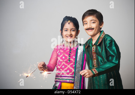 Due bambini imitando come giovane celebra Diwali Festival con botti Foto Stock