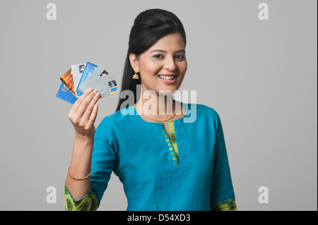 La donna che mostra le carte di credito e sorridente Foto Stock