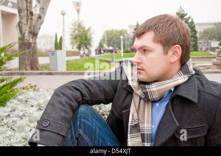 Il giovane uomo è la localizzazione in autunno park Foto Stock