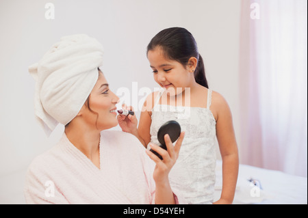 Ragazza il rossetto sulla sua madre labbra Foto Stock