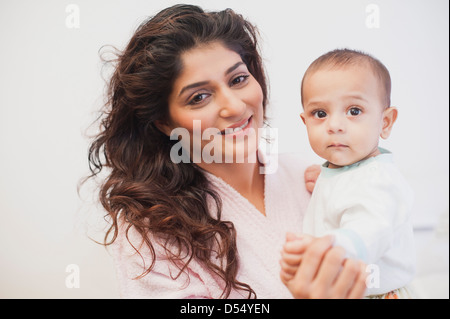 Ritratto di una donna che porta il suo bambino figlio e sorridente Foto Stock