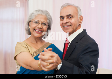 Coppia senior balli presso il loro anniversario e sorridente Foto Stock