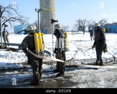 I vigili del fuoco nella protezione chimica tute e maschere antigas erano pronti a fuoco Foto Stock