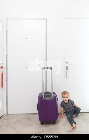 Ragazzo dal rotolamento bagagli nel corridoio Foto Stock