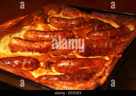 Un vassoio del classico piatto britannico Toad nel foro. Toad nel foro è fatta di salsicce in un Yorkshire pudding pastella. Foto Stock