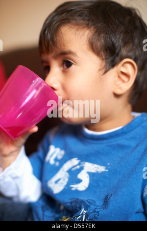 Ragazzo di bere dal bicchiere di plastica Foto Stock