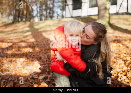 Madre baciare figlio all'aperto Foto Stock
