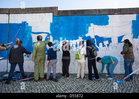 Persone del movimento 'Accidenti Troika pittura un muro contro le misure di austerità, Lisbona, Portogallo. Foto Stock