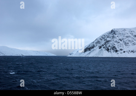 Coperte di neve e rocce aspre coste artiche Norvegia del nord europa Foto Stock