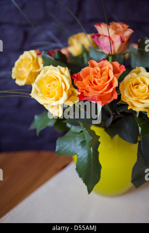 Mazzo di rose in un vaso sul tavolo Foto Stock