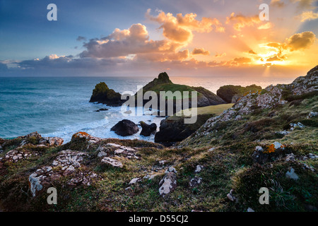 Il sole tramonta su bella Kynance Cove sulla penisola di Lizard della Cornovaglia, Inghilterra Foto Stock