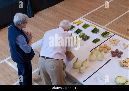 2 giudici valutano la qualità delle voci di vegetali al Burley giardinieri' mostra annuale - Queen's Hall, Burley in Wharfedale, West Yorkshire, Inghilterra, Regno Unito. Foto Stock