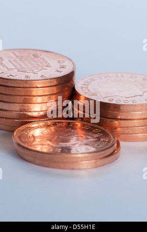 Close-up di nuove brillanti coppers o monetine (British unità di valuta 1p monete) in 3 piccole pile, gran totale del denaro è di 14 pence - Inghilterra, GB, UK. Foto Stock