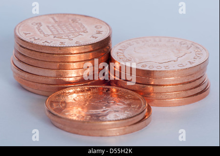 Close-up di nuove brillanti coppers o monetine (British unità di valuta 1p monete) in 3 piccole pile, gran totale del denaro è di 14 pence - Inghilterra, GB, UK. Foto Stock