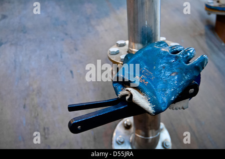 Guanti di gomma giacente su macchine nel posto di lavoro Foto Stock