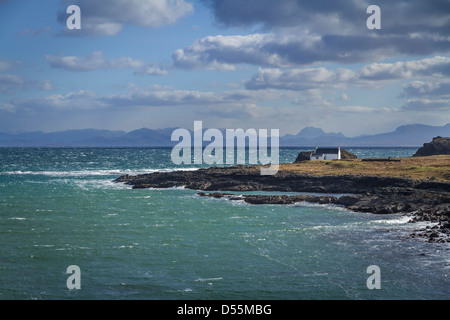 Tradizionale imbiancato croft sulle rive della Baia di Kilmaluag, Isola di Skye in Scozia Foto Stock